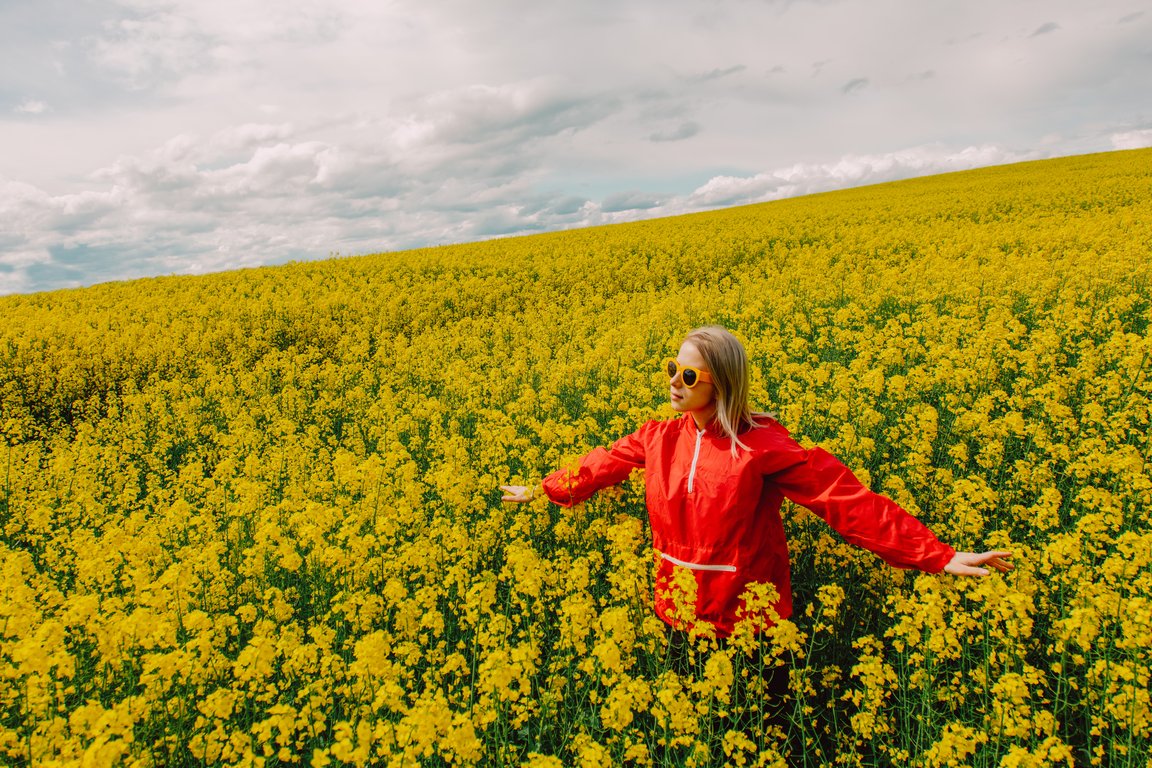Woman in a red jacket in a yellow flower field